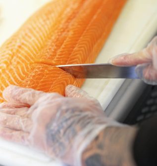 close-of-mans-hands-cutting-fish-on-a-cutting-boar-2022-01-17-18-53-23-utc.jpg